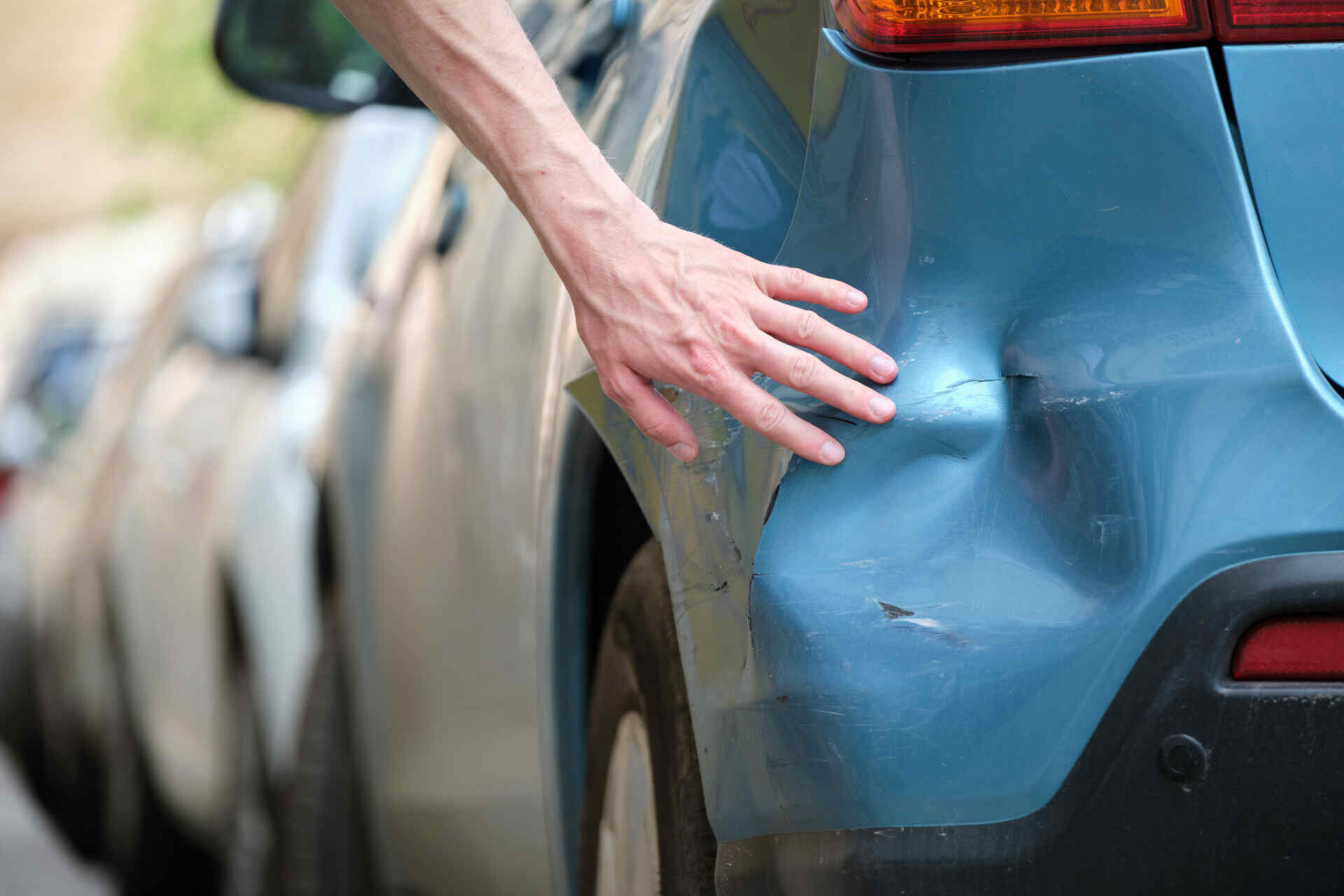 driver examining car after a fender bender in MN