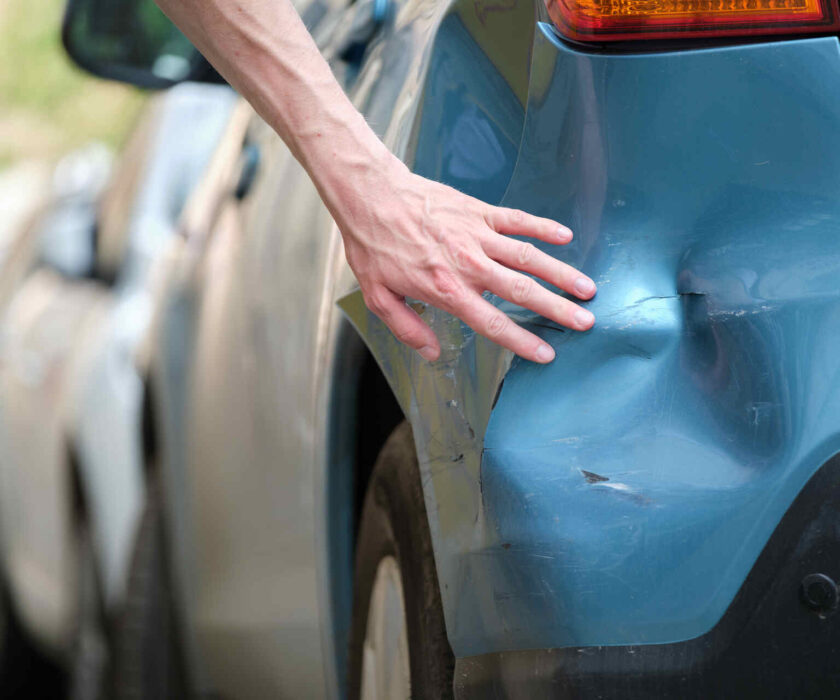 driver examining car after a fender bender in MN